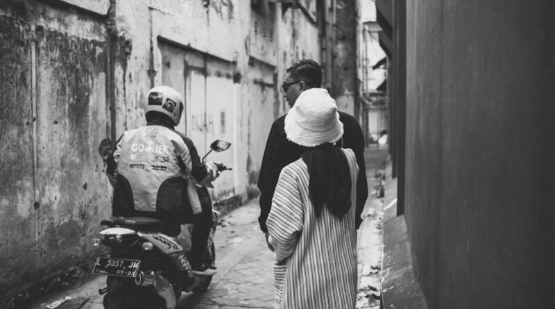 Black and white photo of people and motorcycle in a narrow alley, Surabaya.