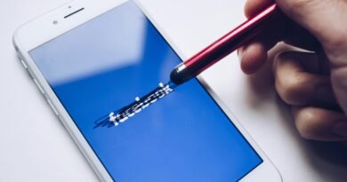 Close-up of a smartphone with a stylus crossing out text on its screen.