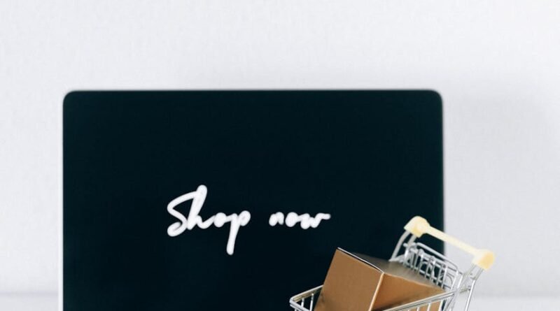 Minimalist online shopping setup with laptop, cart, and packages symbolizing e-commerce.