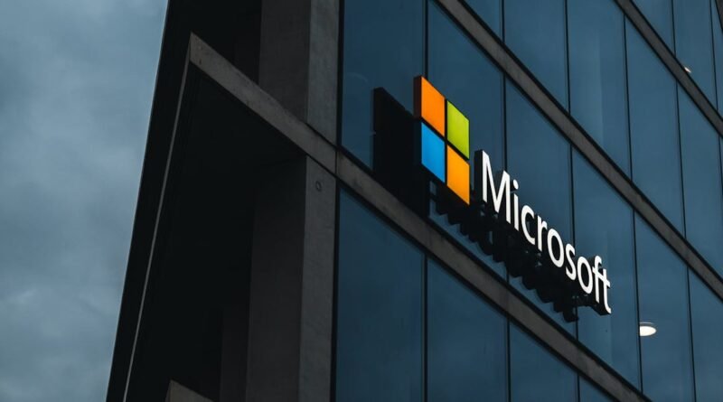 A modern Microsoft office skyscraper with glass facade against a cloudy evening sky.