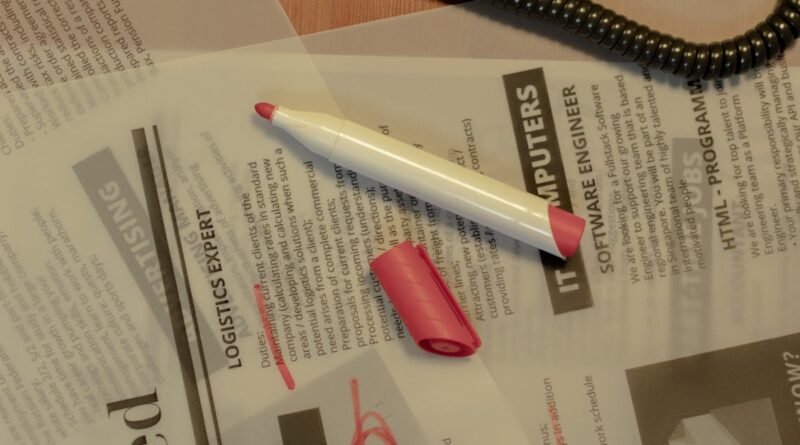 Close-up of a job search scene with a newspaper, red marker, and telephone, indicating job hunting.